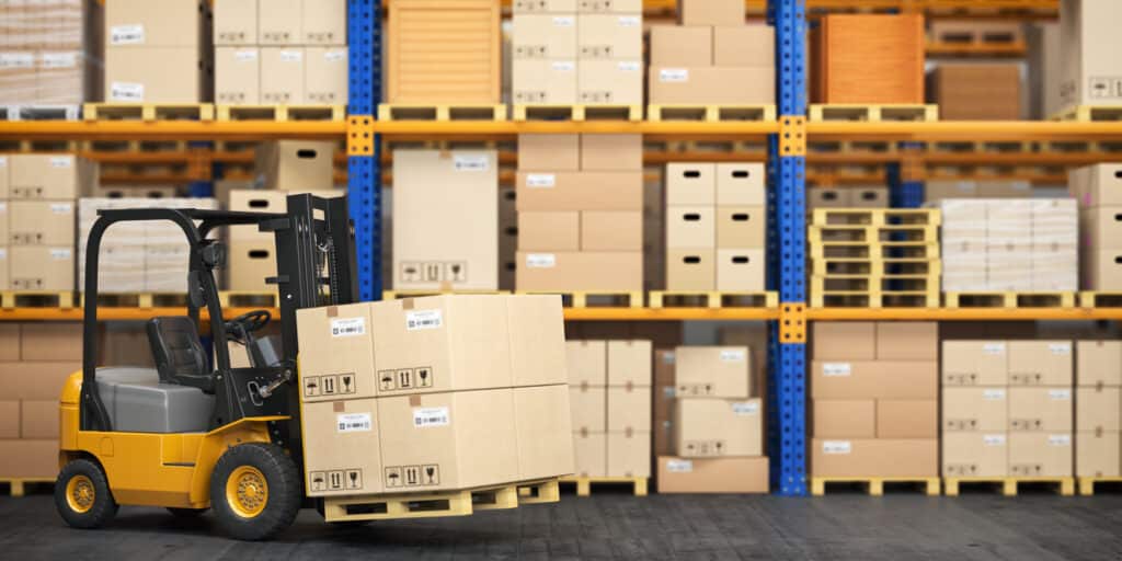 forklift in West Palm Beach carrying cardboard boxes in a warehouse with shelves stocked with goods.